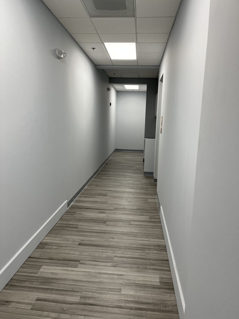 Finished commercial corridor with gray walls and plank flooring