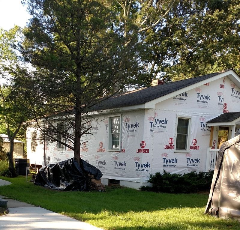 House wrapped in house wrap during remodel — before