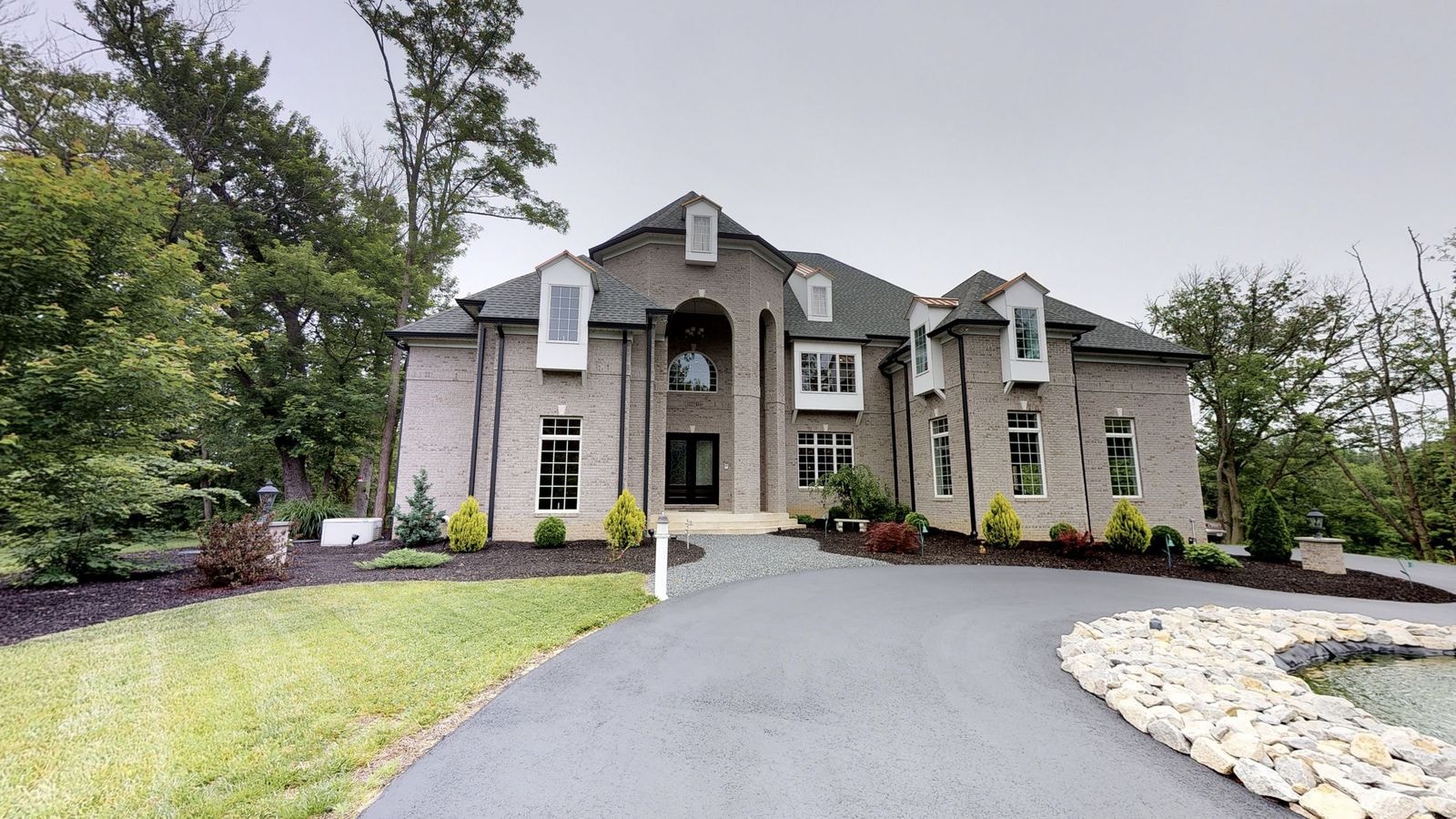 Brick custom home with arched entry and circular driveway