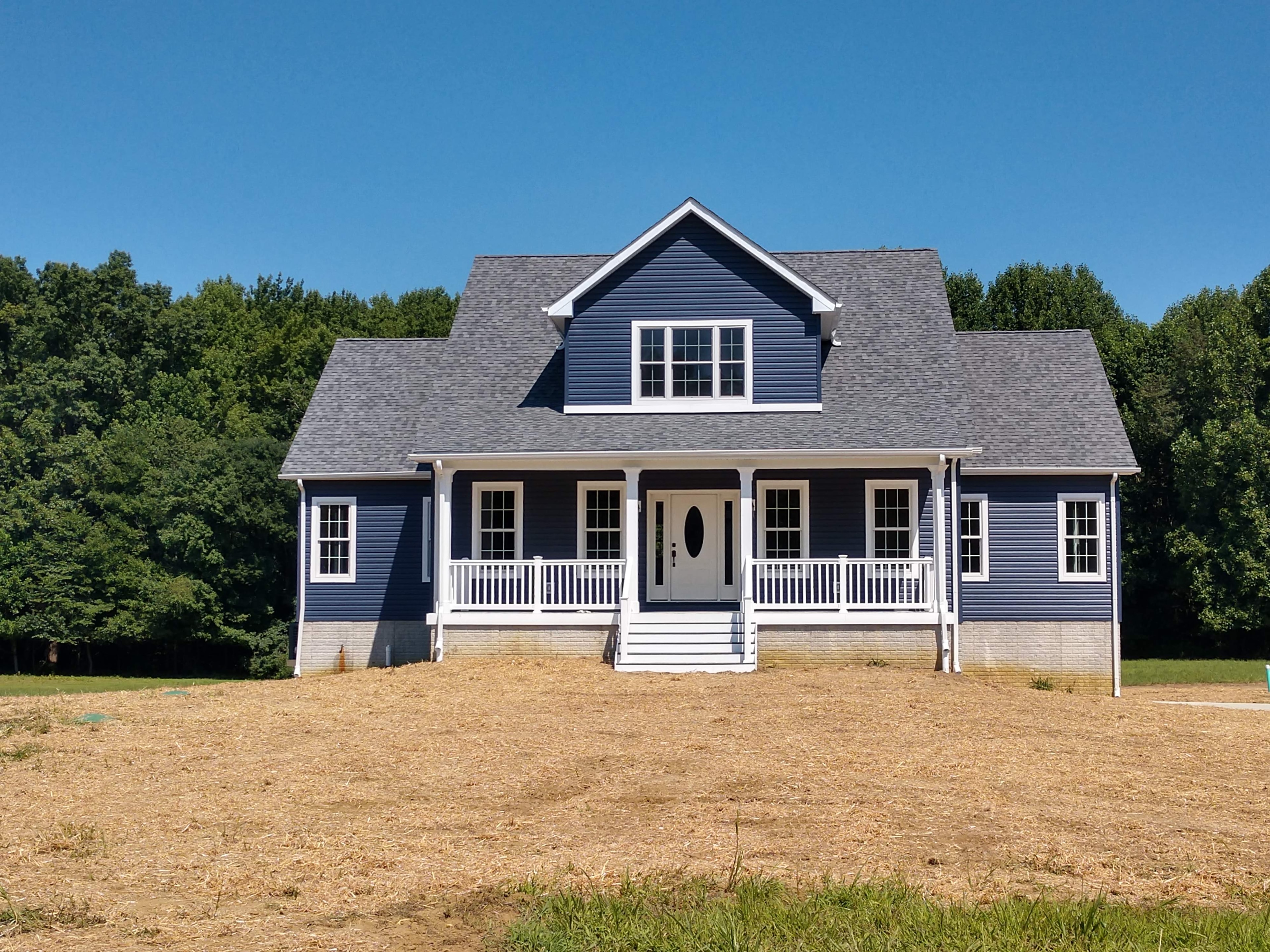 New two-story home with navy siding and covered front porch